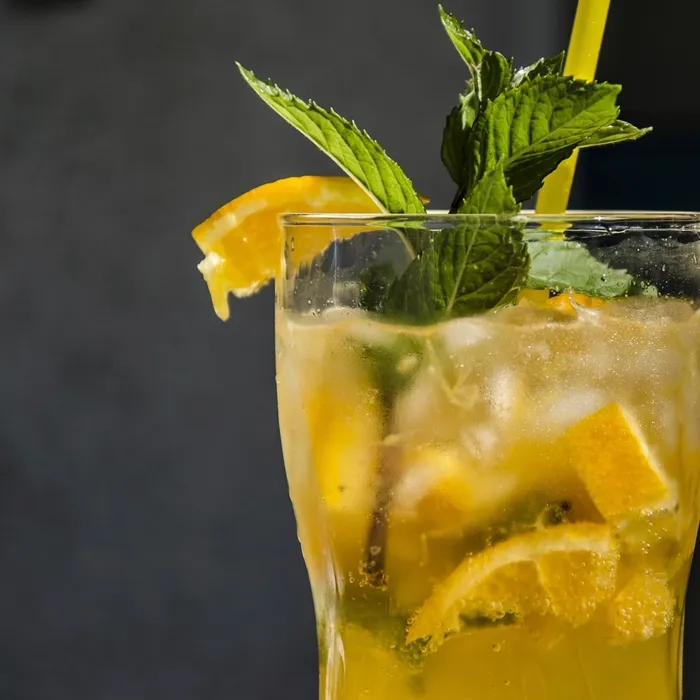 Caipirinha de laranja com hortelã servida em copo alto com gelo
