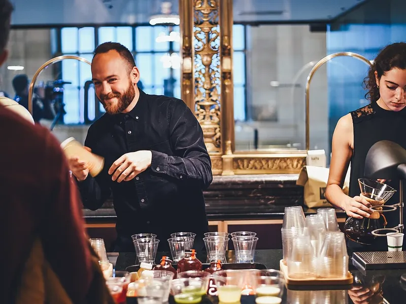 Bartender batendo drink na coqueteleira durante evento corporativo
