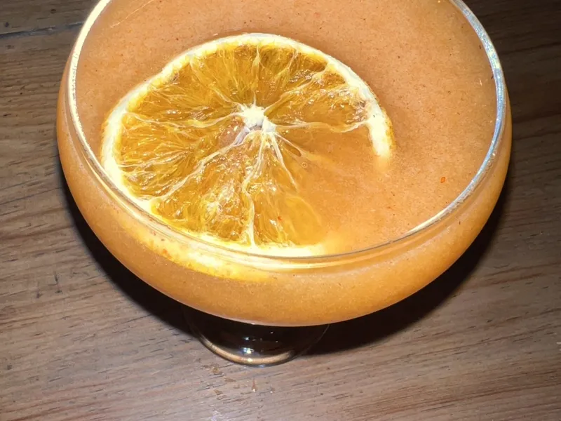 Drink autoral em taça coupe finalizado com rodela de laranja desidratada