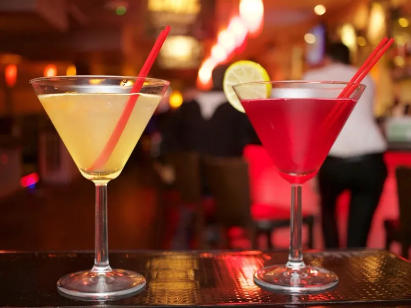 Dois drinks servidos em taças no balcão do open bar